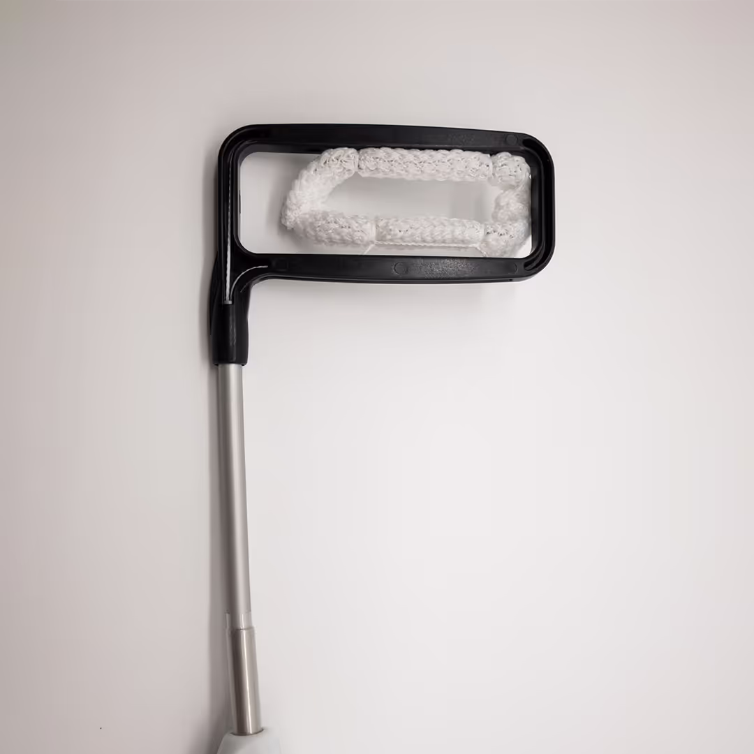 Vista em detalhe do clipe implantável do dispositivo AtriClip, destacando sua estrutura retangular preta e o tecido de poliéster branco responsável pelo fechamento do tecido.