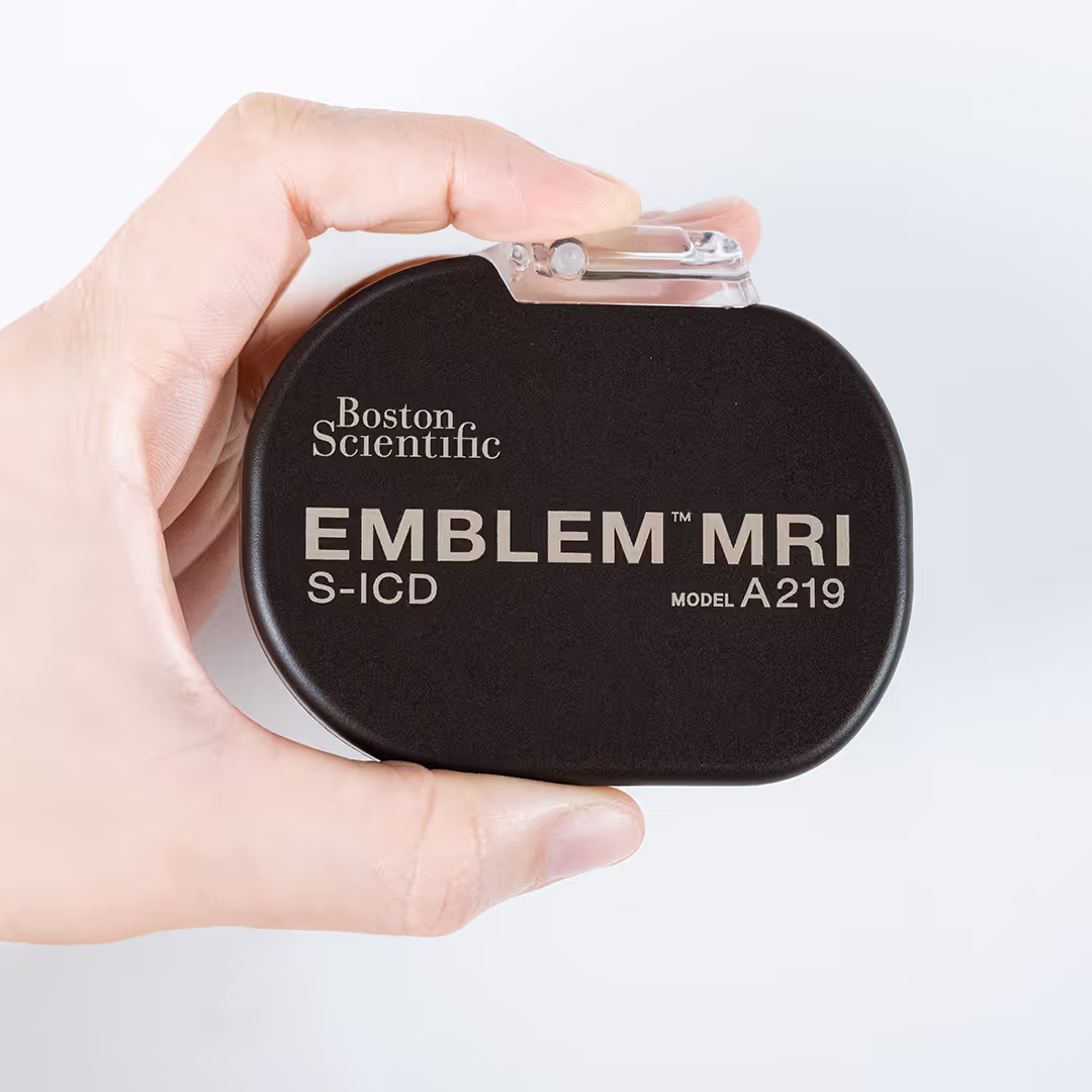 Mão segurando o desfibrilador subcutâneo EMBLEM™ MRI S-ICD, modelo A219, da Boston Scientific, utilizado na prevenção de arritmias ventriculares fatais.