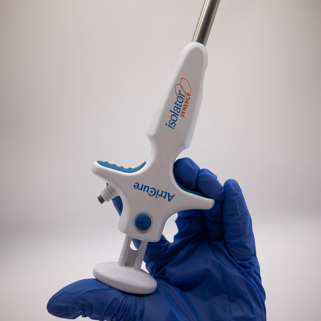 Close-up do manípulo ergonômico do clamp AtriCure Isolator Synergy, sendo segurado por uma mão com luva cirúrgica.